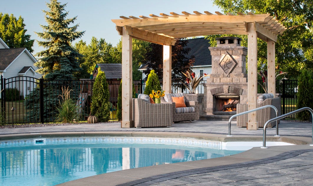 Outdoor fireplace: Bristol Belgard Elements. Pool deck and patio: Lafitt® Rustic Slab.