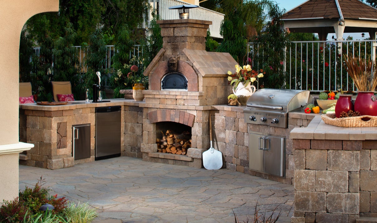 This well-appointed outdoor kitchen and bar includes seating, outdoor refrigerator, kegerator, Bristol Brick Oven, built-in grill, sink and storage.