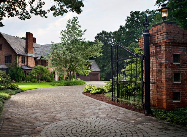 Pavers can be hand-cut to create serpentine paths or add geometric shapes and designs. A circle of Cambridge Cobble was added to the design of this Old World paver driveway to create a grand entrance that begins at the property gate.