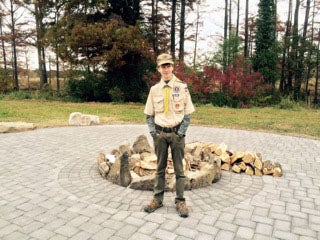 Future Eagle Scout Timothy Bedford displays the completed Warrior Fire Pit project her organized and help build for Landing Zone Grace Warriors Retreat.