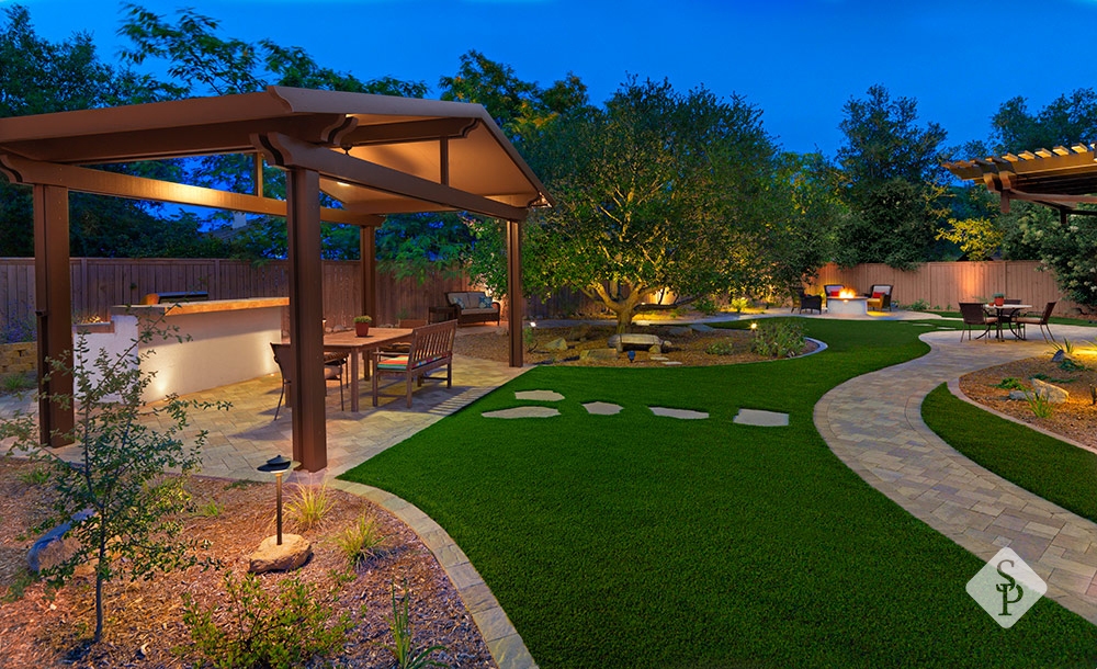 outdoor living space with turf and pergola 