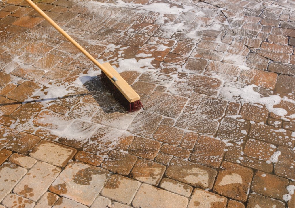 Cleaning pavers with a bristle broom