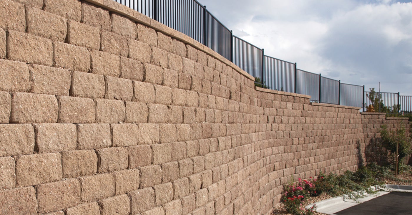 outdoor stone retaining wall installation with fence in austin texas