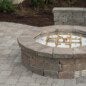 Gas circle firepit with a kneecap wall for sitting.