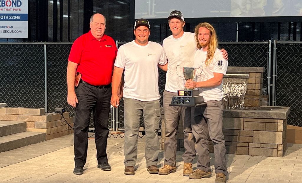 Robert Bowers of ICPI award the championship trophy to Nico Phelps, Cohan Fish and Durant Fish.