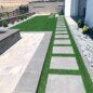 A paver patio and artificial turf installed in a backyard.