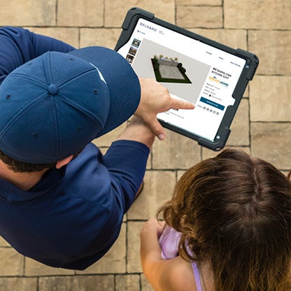 Entrepreneur utilisant la fonction AR de Belgard sur une tablette pour présenter les designs de Rooms à un client.