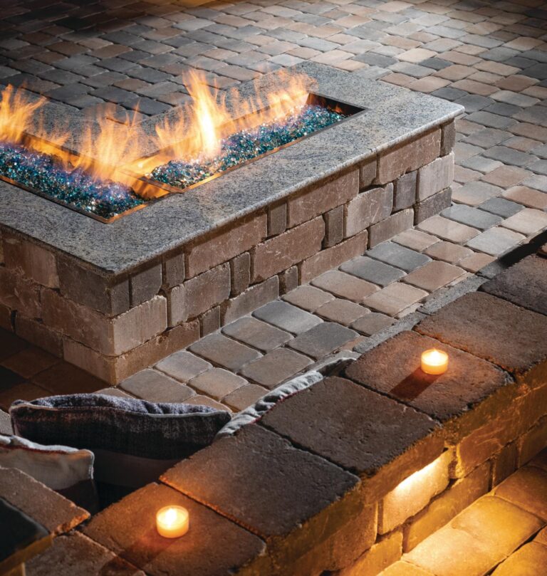 built-in L-shaped cobbled paver patio with custom fire table