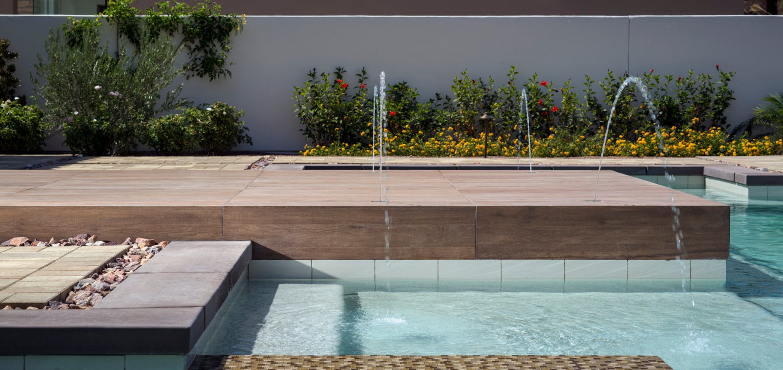 Terrasse de piscine : pavés en pierre Catalina et pavés en porcelaine Mirage® Sundeck.